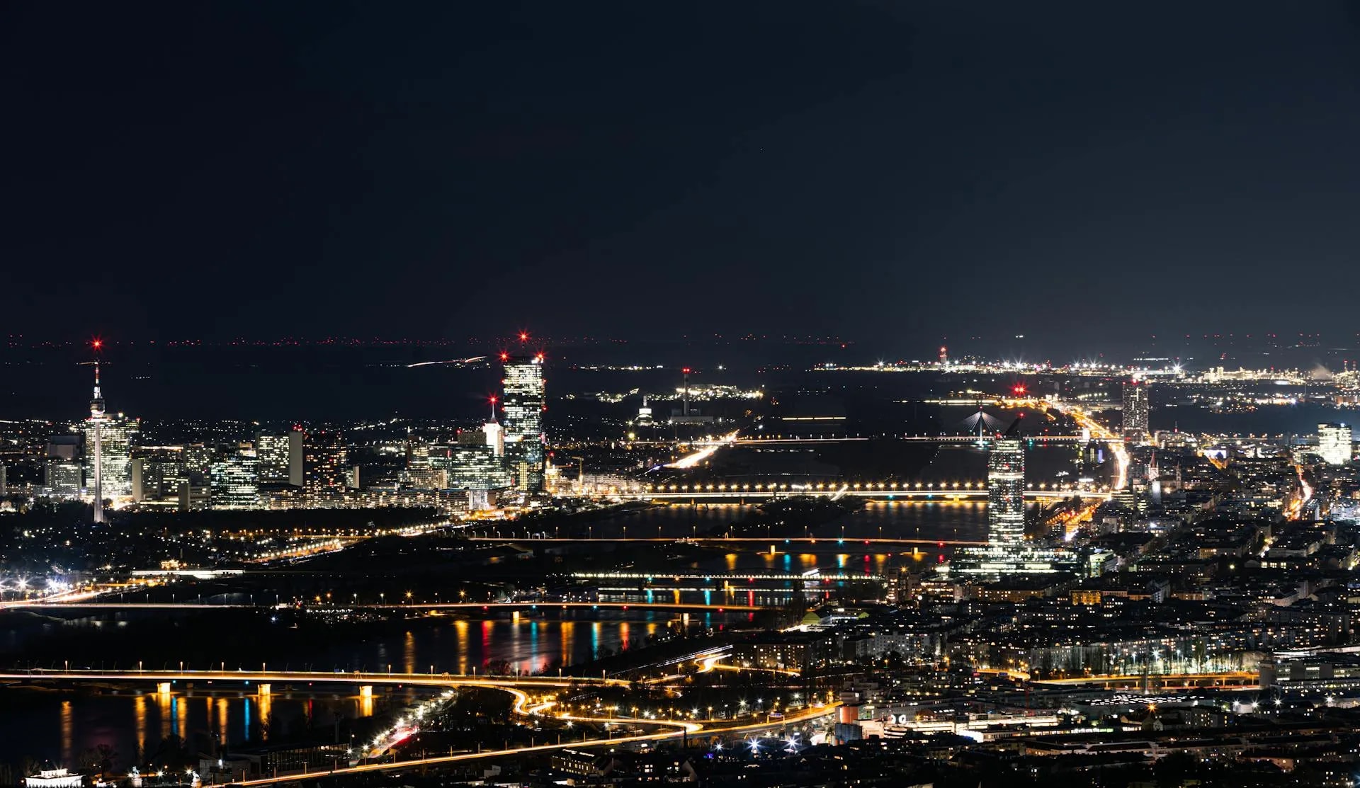 Vienna city skyline illuminated at night along the Danube